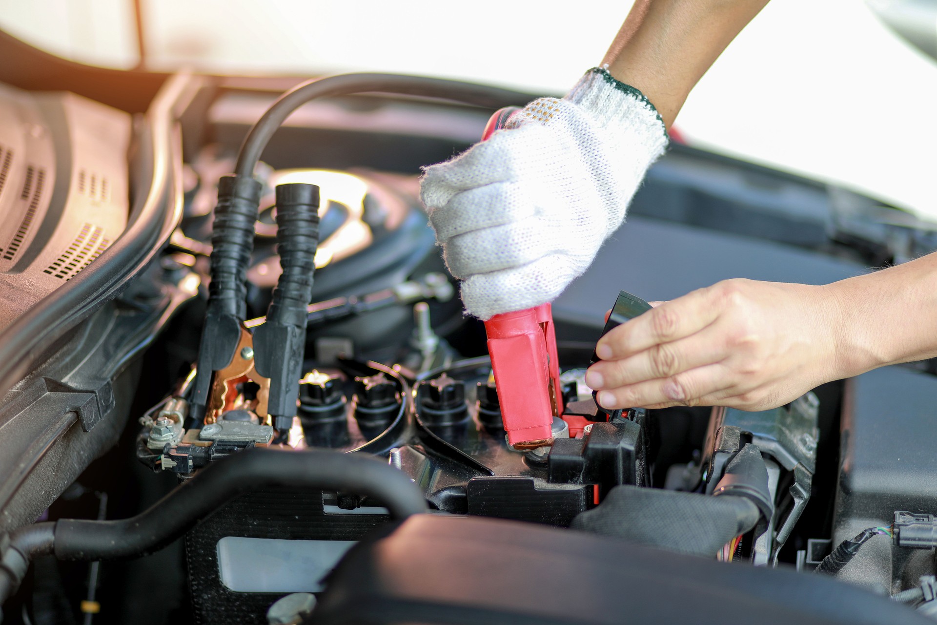 Close up Charging car battery with electricity trough jumper cables. Car repair concept.